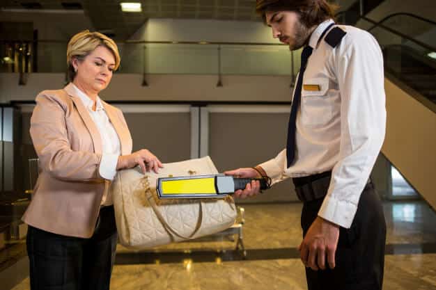 airport security officer using metal detector check bag 107420 85055 1 2